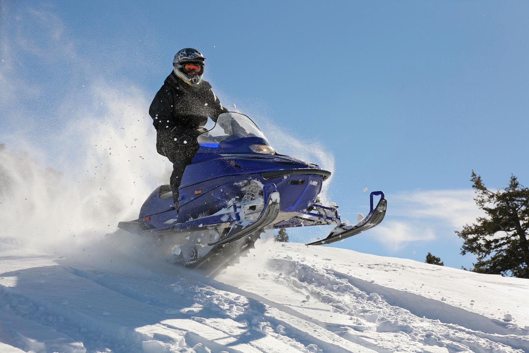 extreme snowmobile rider racing machine through powder in mounta